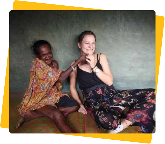Two women laughing together in a village