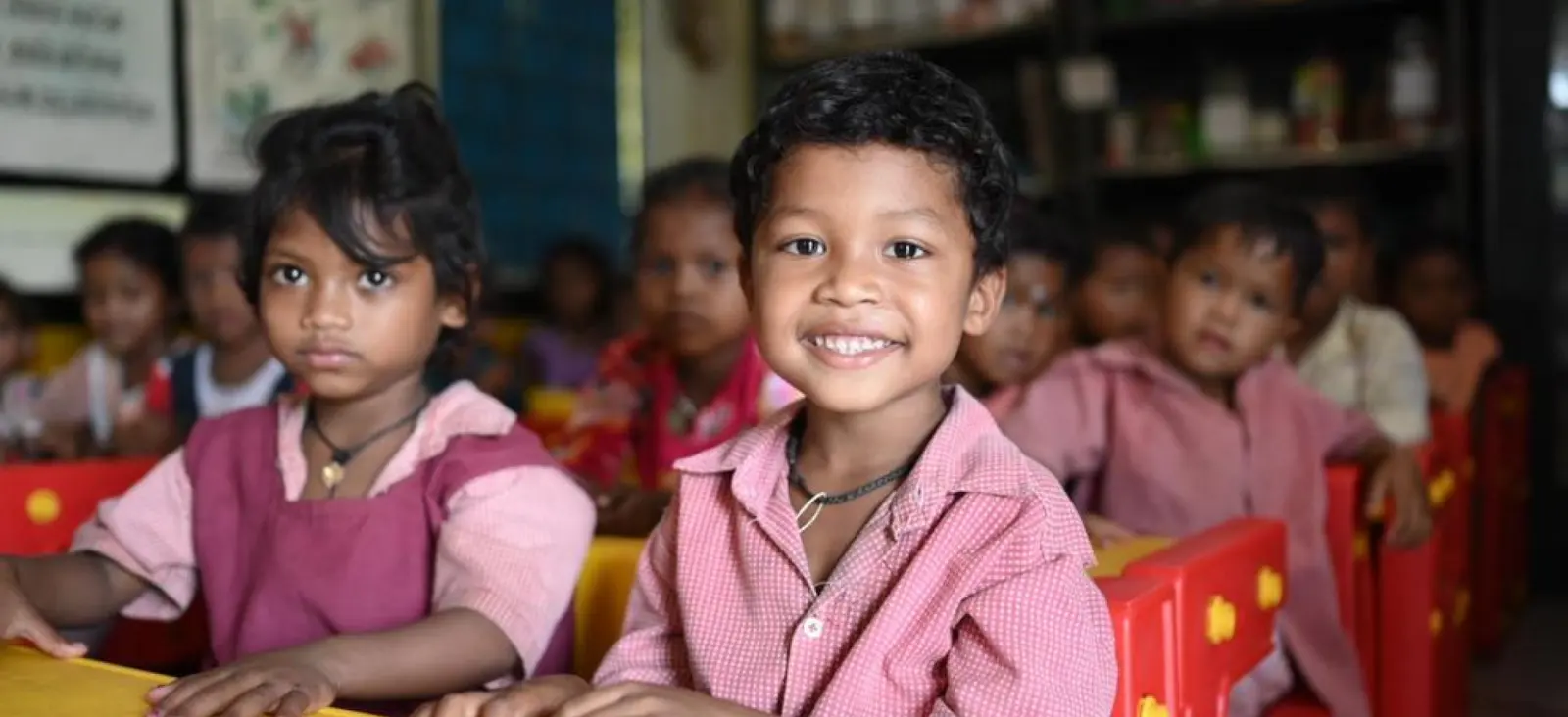 Children in a village classroom, smiling at the camera